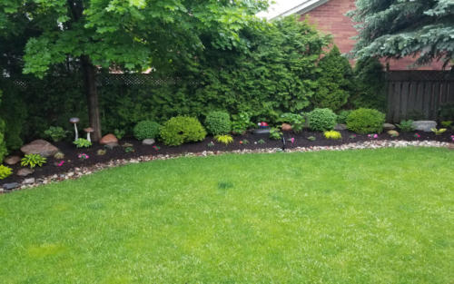 backyard garden with river stone edge 