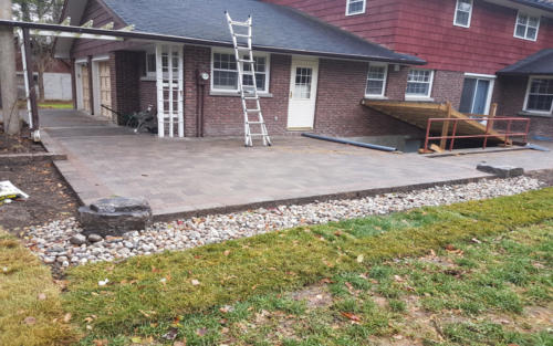 backyard paver patio with river stone