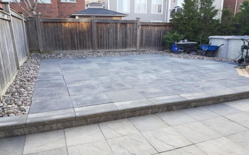 backyard paver patio with river stone border